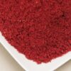 A white plate topped with red food.
