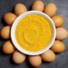 A bowl of yellow food and some eggs