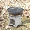 A grill sitting on top of the ground in leaves.